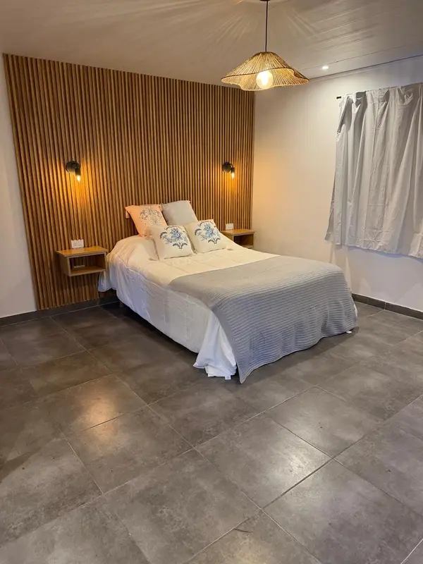 Cabaña Sol: cama de dos plazas con respaldo de madera y luz cálida